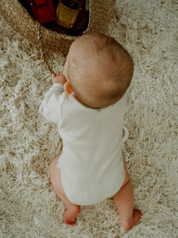 Vaniljan sävyinen Uskallus Body vauvan päällä