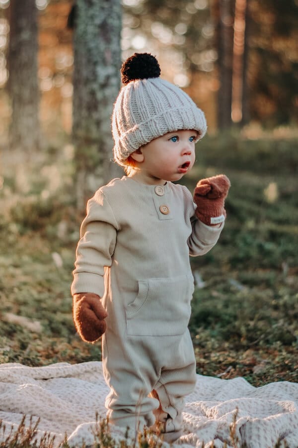 Pipopäinen lapsi metsässä ihana beigen sävyinen ribbi haalari yllään